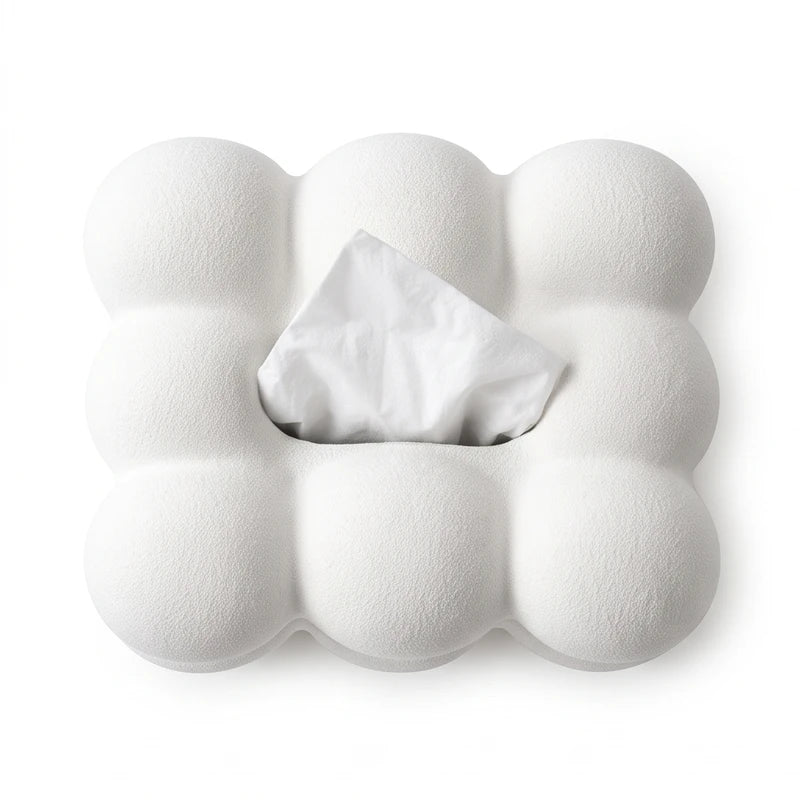 Textured white cloud-shaped tissue dispenser with a single white tissue peeking out from the center opening, on a white background.