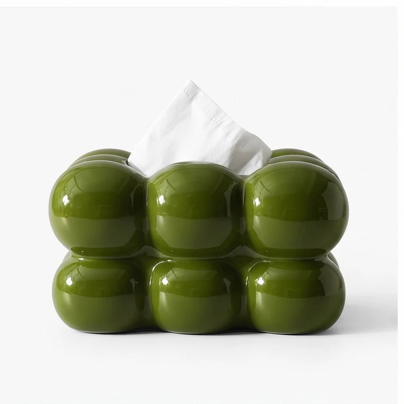 Glossy olive green tissue box cover with a bubble-like design, holding a white tissue, against a plain white background.