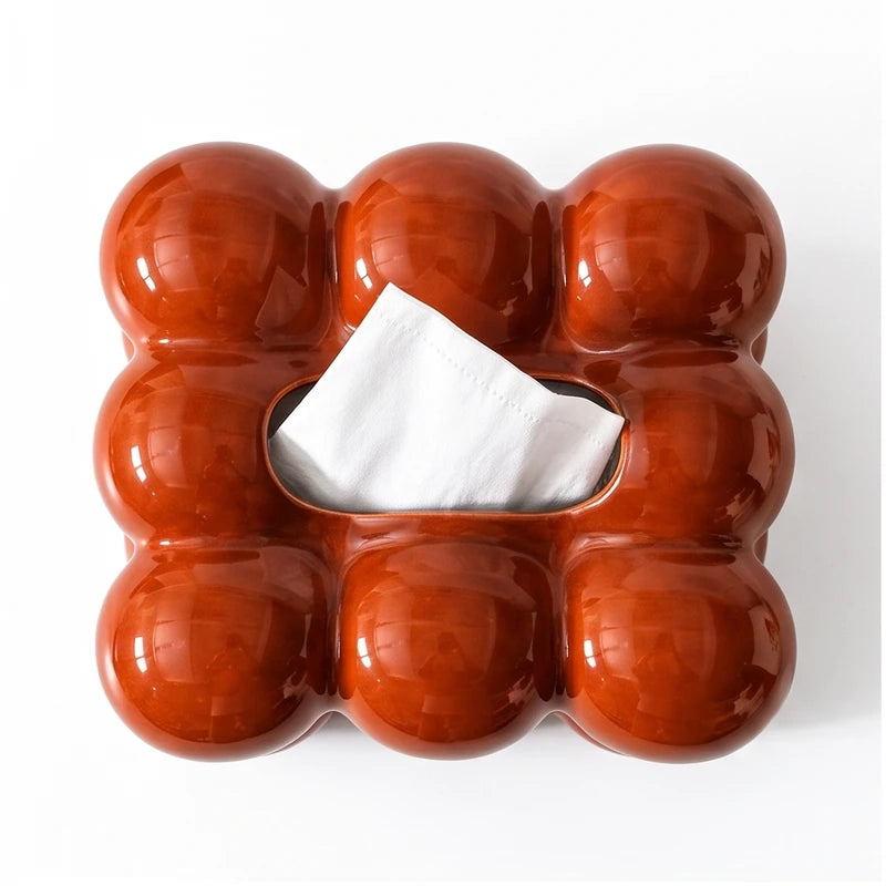 Glossy reddish-brown rectangular container with nine rounded sections and a white tissue emerging from the center slot.
