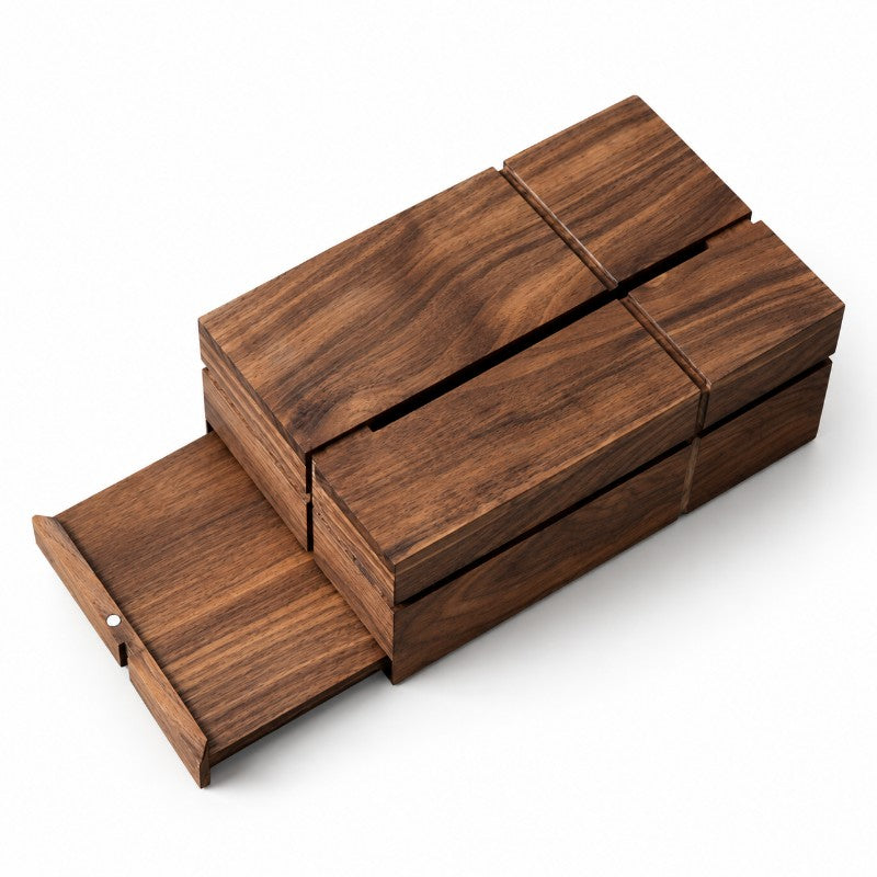 Dark brown wooden box with geometric slatted top, one panel slides out revealing a small magnetic closure, on a white surface.