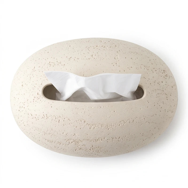 Light beige oval tissue dispenser with a textured surface, featuring a slot from which a white tissue protrudes.